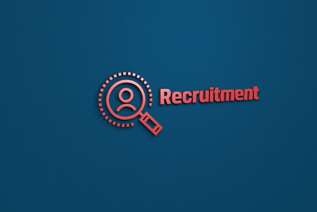 A 3D red icon of a magnifying glass over a person silhouette next to the word "Recruitment" on a blue background.